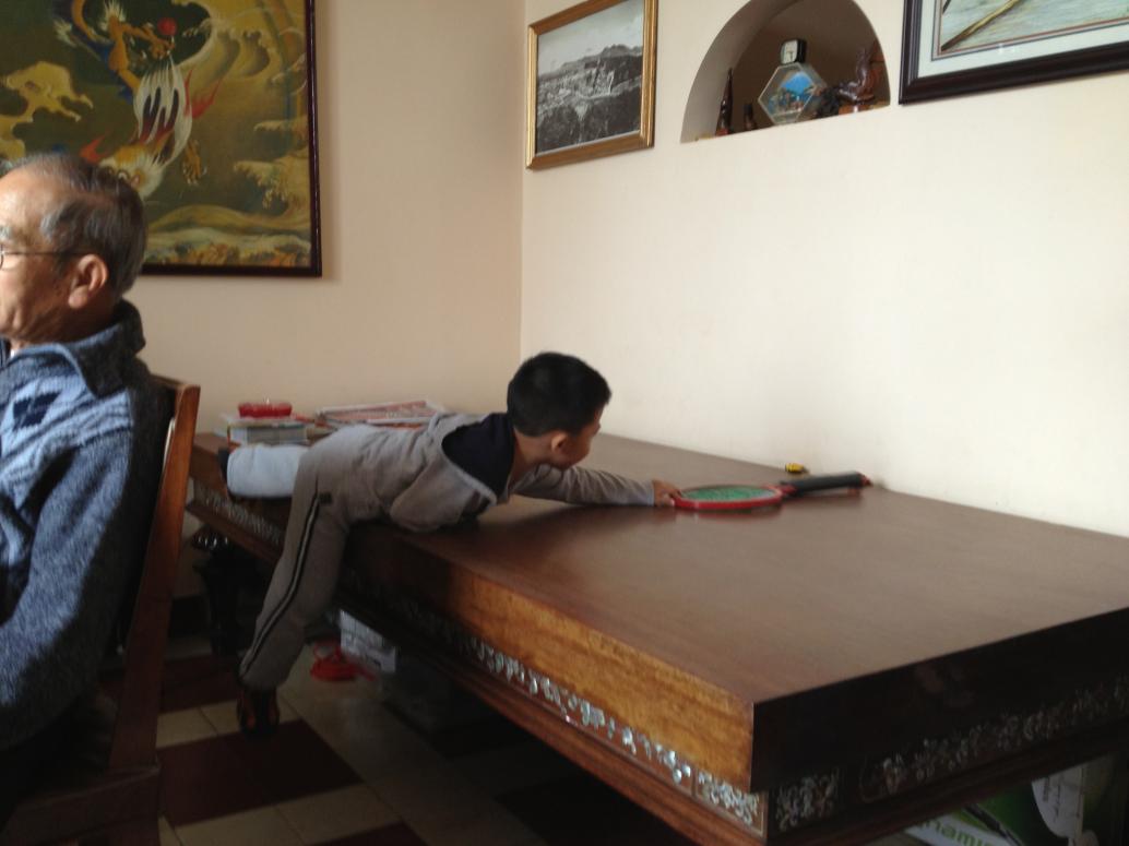 Con cầm cái vợt muỗi của Ông Ba để lấy cái xe.