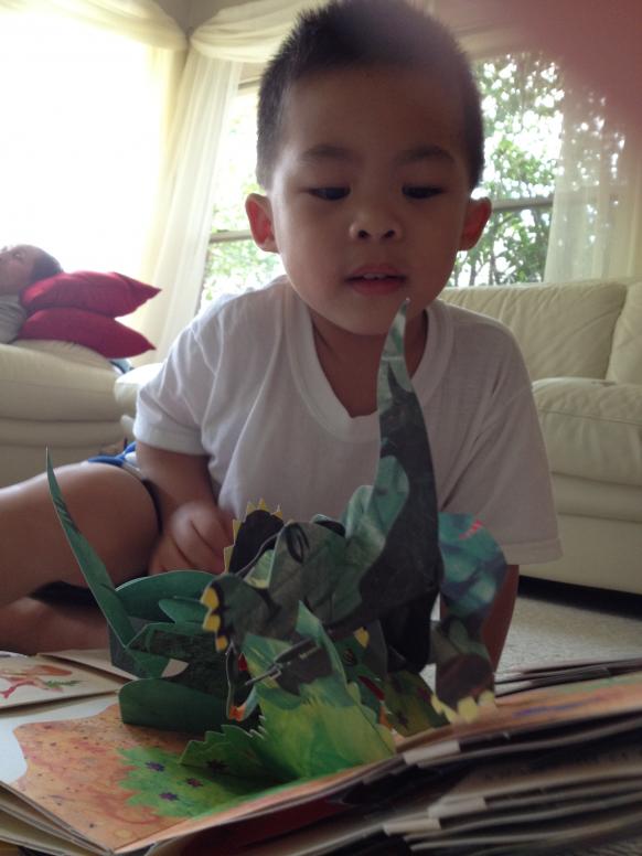 Chà, có con khủng long từ trong sách đứng lên.