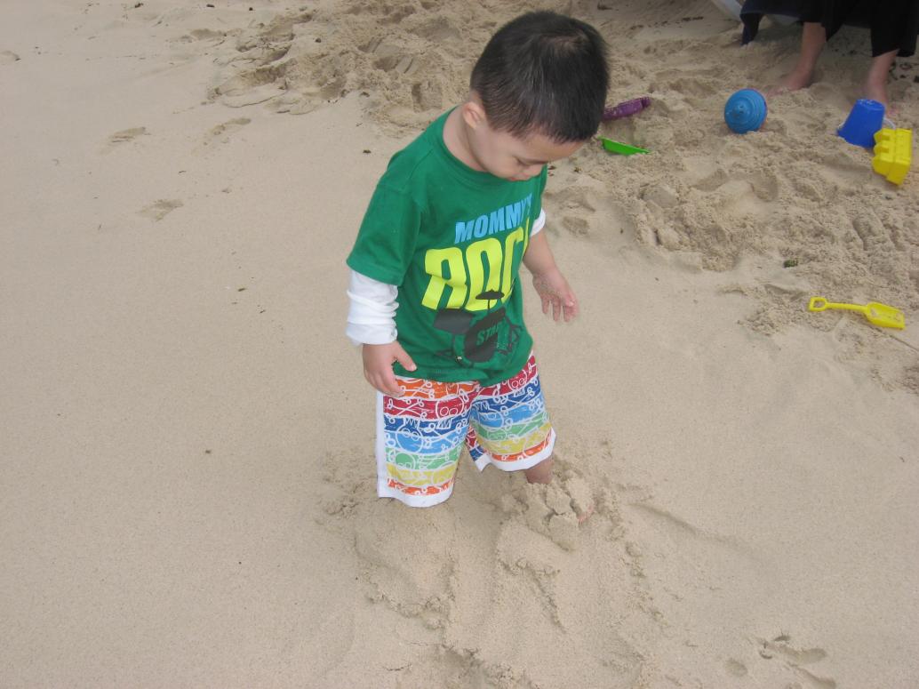 Con xuống biển lần đầu tiên. Mới đầu lấy tay phủi cát liên tục.