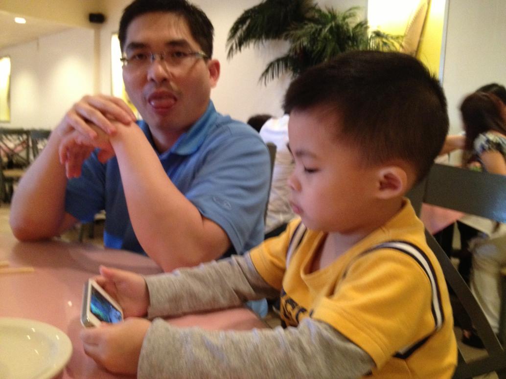 Cúc Cu coi phim hoạt hình chờ đồ ăn lên.